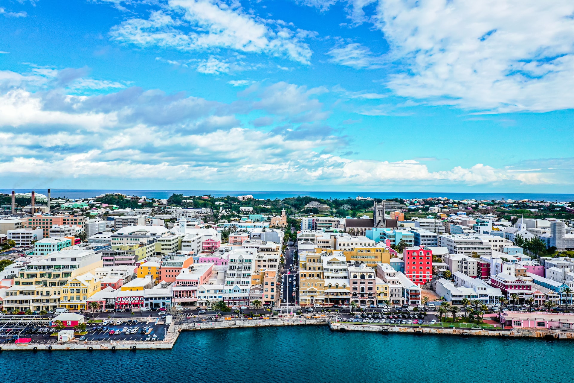 Aerial view of Front Street in Hamilton, Bermuda, with buildings in different colors and the dark blue ocean