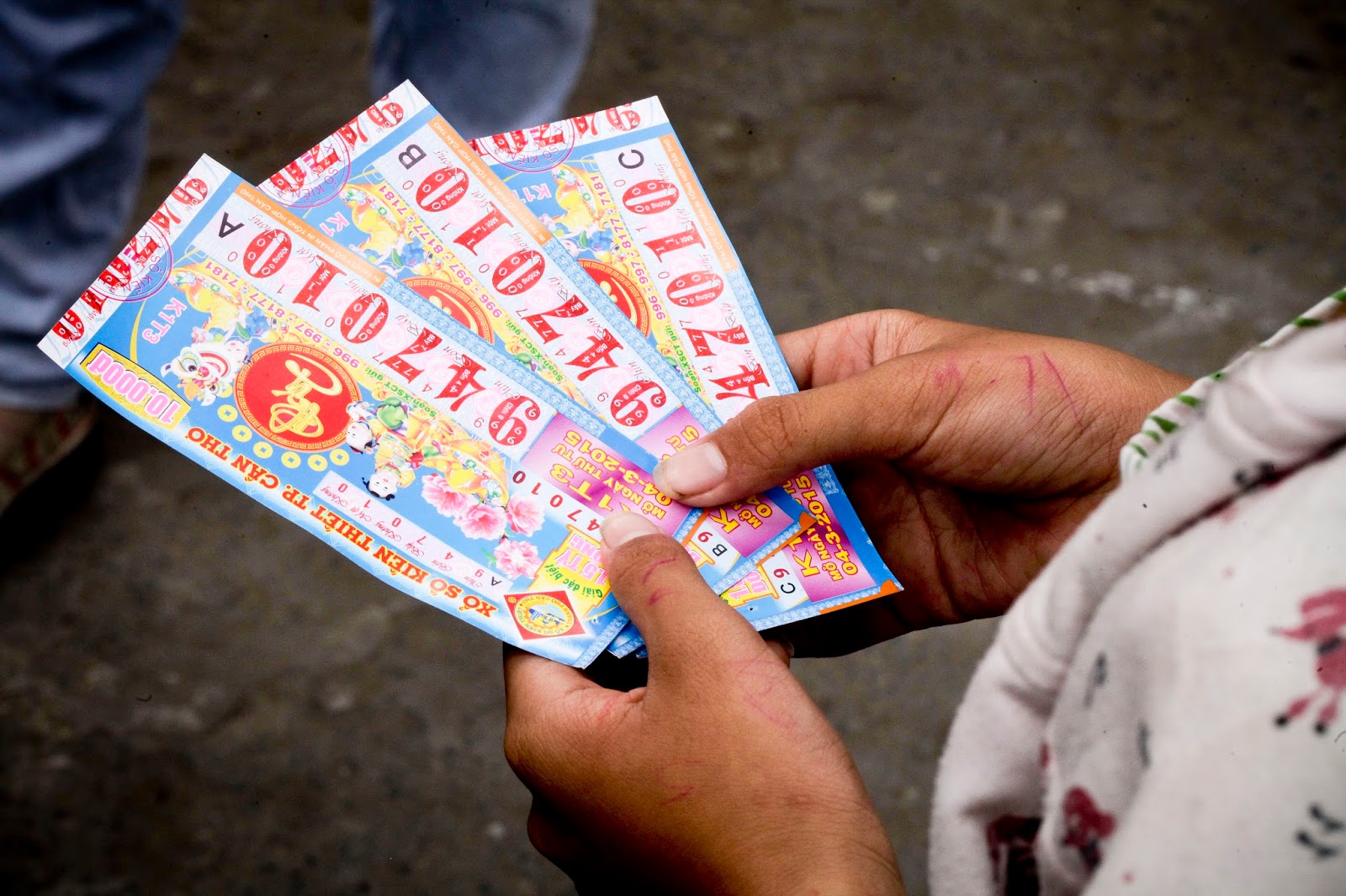 A women holding the three lottery tickets in her hands